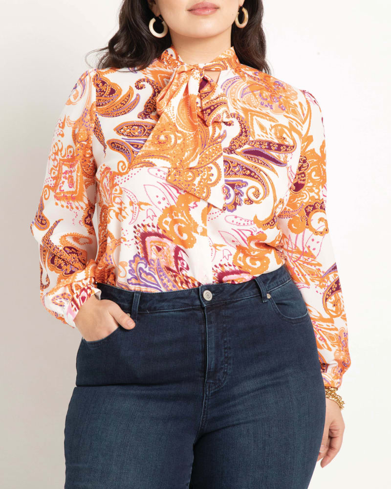 Front of a model wearing a size 14 Reina Tie Neck Blouse in Day Tripper by ELOQUII. | dia_product_style_image_id:195717